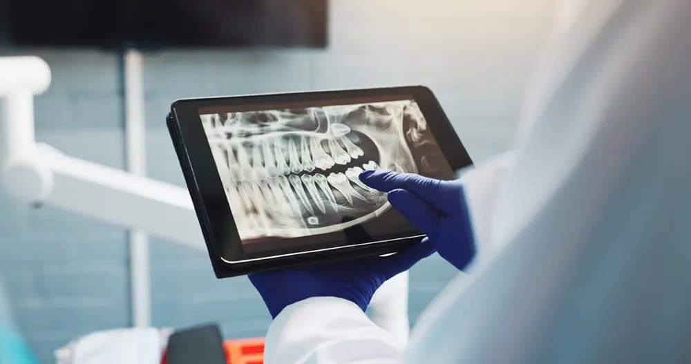 Médico a analisar exames digitais numa clínica de implantes dentários.