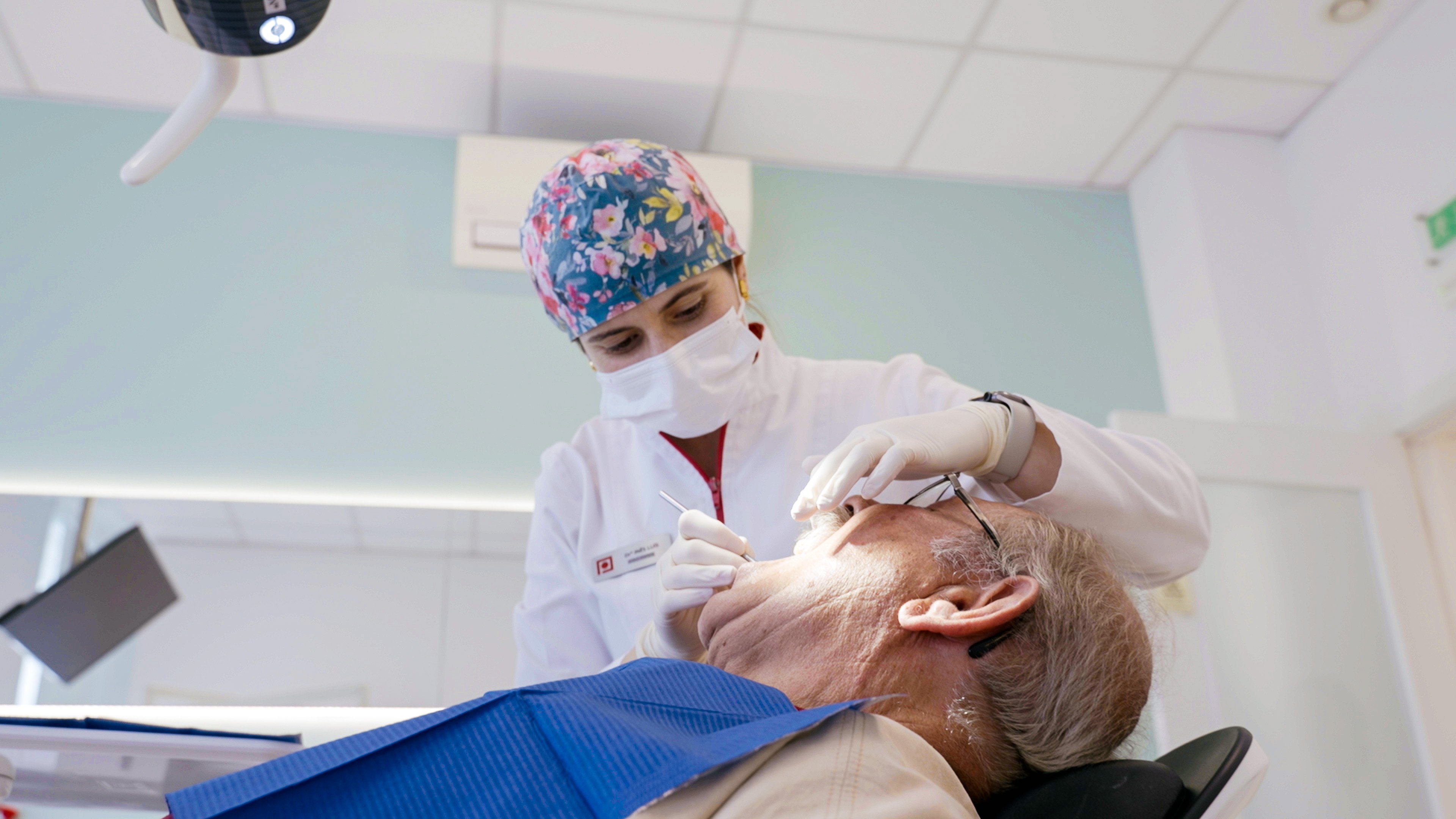 Médica dentista a realizar a primeira avaliação clínica para planeamento de implantes dentários