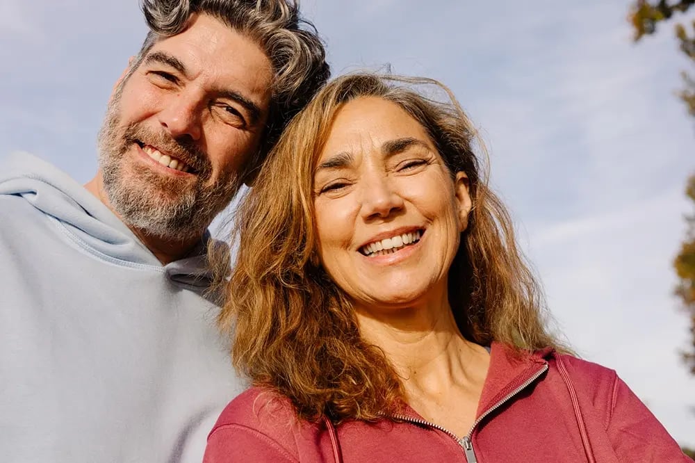 Casal adulto a sorrir após tratamento com implantes dentários de carga imediata